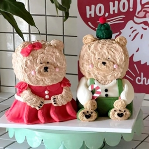 Detail of Christmas bear cake toppers with cream-like texture and festive red green outfits