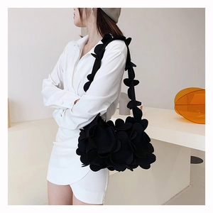 Close-up of black 3D petal shoulder bag with textured floral design and sculptural aesthetic