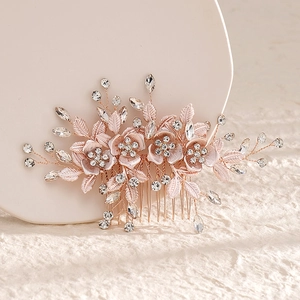 Detailed view of a rose gold floral hair comb with rhinestones and metal leaves