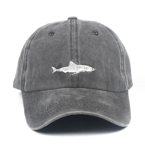 Close-up of a white shark embroidery on a dark grey washed denim baseball cap