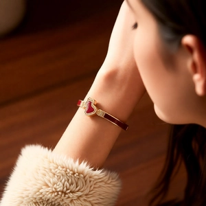 Detailed view of an 18k gold-plated gourd bracelet with red enamel and pavé-set stones