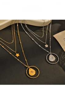 Detailed view of layered 14K gold and silver necklaces featuring star and teardrop pendants