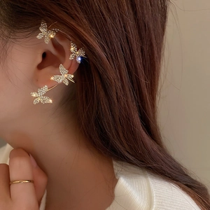 Detail of elegant gold butterfly ear cuff with sparkling rhinestones worn on ear