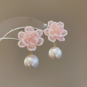 Macro shot of pink beaded flower earrings with a large lustrous white round pearl