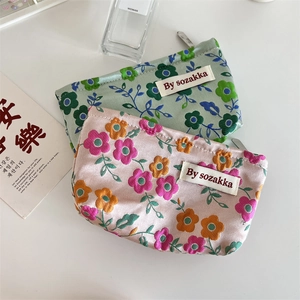 Detailed view of floral satin cosmetic bags with zip closure and premium embroidery