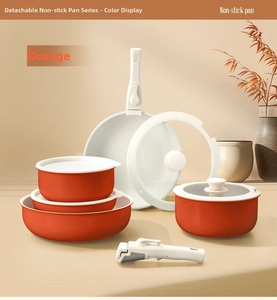 Orange non-stick cookware set with detachable handle and glass lids on a warm background