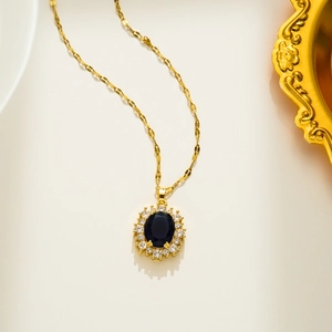 Close-up of golden necklace with oval blue crystal and shimmering zircon stones