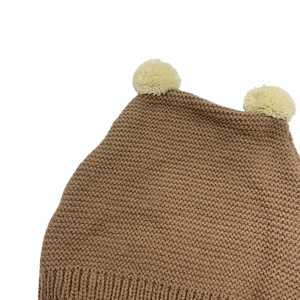 Brown knitted baby beanie with dual cream pom-poms and ribbed cuff for winter warmth