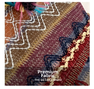 Macro detail of ethnic embroidered fabric with colorful wave patterns and fringe decorative