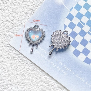 Macro detail of fluid heart charm with blue rhinestones showing 12mm and 18mm sizes