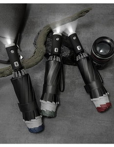 Three automatic umbrellas with LED flashlights on a textured gray professional stone surface