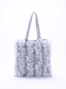 Detalle de bolso de malla azul con volantes que muestra capas plisadas y estilo dulce