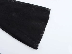 Détail de la manchette en dentelle noire avec des motifs complexes en tulle fleuri