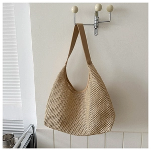 Detail of hollow-out woven texture on a khaki summer beach tote bag with wide strap