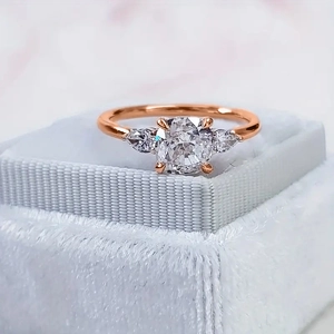 Macro-opname van een roségouden ring met kussengeslepen zirkoon in blauw fluwelen doosje