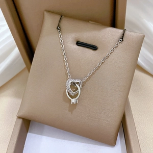 Dettaglio della collana cuore in argento con diamanti brillanti su cuscino di seta
