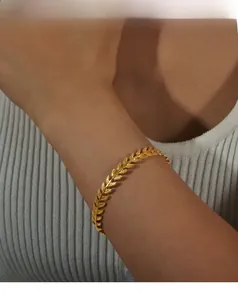Detail of gold wheat ear engraved cuff bracelet showing delicate textured metal leaf pattern
