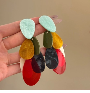 Detail view of large acrylic teardrop earrings with layered multi-color fringe design