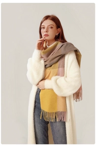 Close-up of pink and yellow plaid scarf with fringe details and soft woven texture