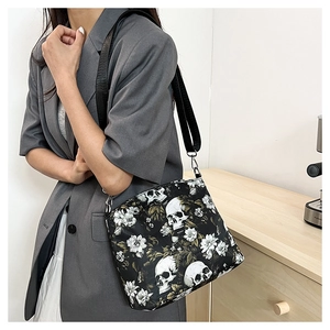 Detail of skull floral jacquard shoulder bag showing size and drape on a grey blazer