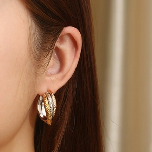 Macro shot of gold silver and copper interlocking earrings with vintage floral engravings