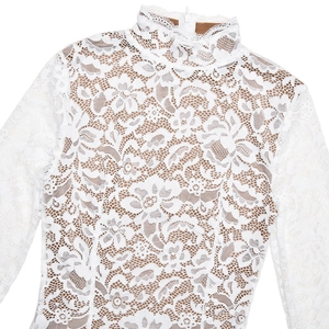 Detail of white lace dress showing floral patterns, high neckline, and back zipper closure