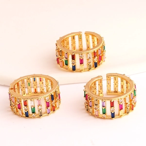 Detail of three gold open rings with colorful rectangular zirconia in a triangle layout