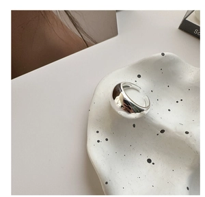Dettaglio macro della superficie lucida a specchio di un anello aperto in argento