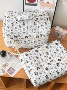 Detail of white quilted cosmetic bag set featuring cute cartoon dog and bear patterns
