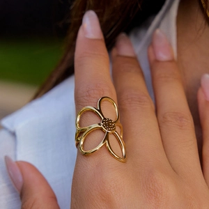 Gold-plated floral pearl ring with hollow five-petal flower design worn by a model