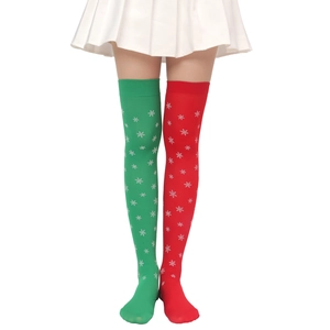 Detail of red and green Christmas over-the-knee socks featuring white snowflake patterns
