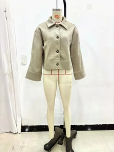 Détail du manteau court taupe avec boutonnage simple et revers de col surdimensionnés