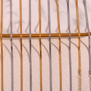 Detailed comparison of gold and silver flat snake chains with polished textures