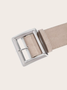 Gros plan sur une ceinture en daim beige vintage avec une boucle carrée en métal argenté