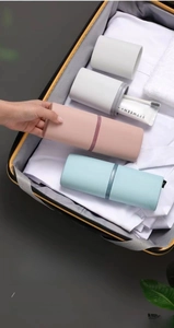 Portable travel wash cup storage box inside a suitcase with toothbrush and toothpaste
