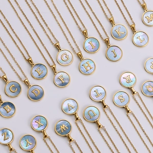 Detailed macro view of 18k gold plated stainless steel necklaces with blue shell letter charms
