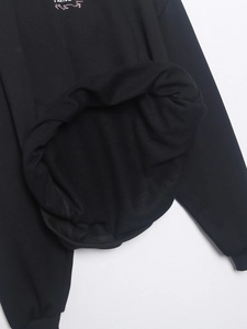 Detalle de la sudadera negra mostrando el forro interior de tela de rizo suave y textura