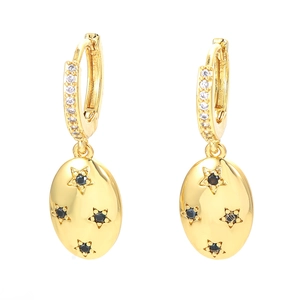 Detail of gold star drop earrings with micro-set white zircon and black gemstone stars