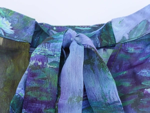 Detailaufnahme des Ölgemälde-Seerosenmusters auf Chiffonstoff mit einer eleganten Schleife