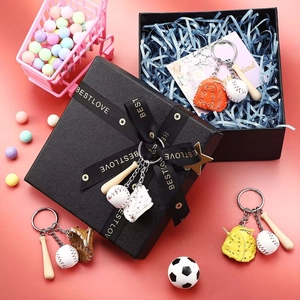 Close-up of baseball keychain set with wooden bat and glove in a branded gift box