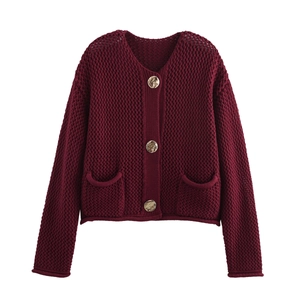 Detailed macro view of dark wine red knit cardigan featuring texture and gold buttons