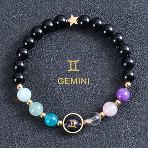 Detail of beaded Gemini zodiac bracelet with blue sandstone and gold star charm
