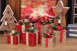 Detail of red and gold Christmas LED gift boxes with glitter mesh and pine needle accents