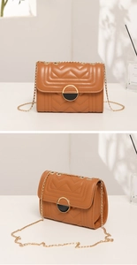 Detail showing the brown quilted V-pattern and gold chain strap of the crossbody handbag
