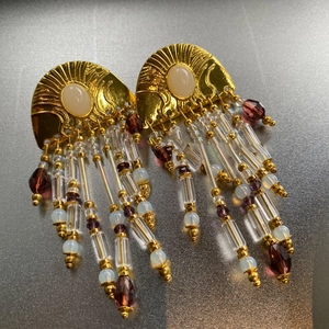 Detailed macro of vintage fan earrings with beaded tassels and gold-plated finish