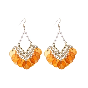 Bohemian gold hoop earrings with white pearls and orange shell pendants on white background
