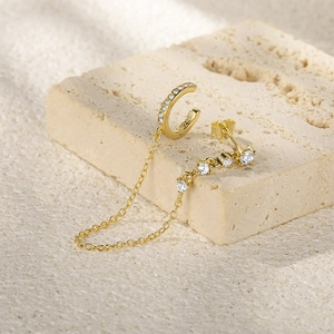 Macro detail of S925 sterling silver ear cuff and stud with diamond chain in gold