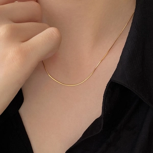 S925 sterling silver gold plated snake bone chain necklace worn by a model over a black shirt