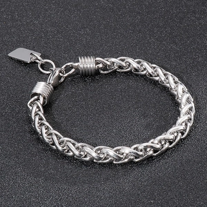 Macro detail of men's stainless steel wheat chain bracelet with polished lobster clasp