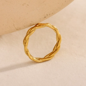 Minimalist 18K gold plated braided ring with a polished twisted texture on ceramic stand